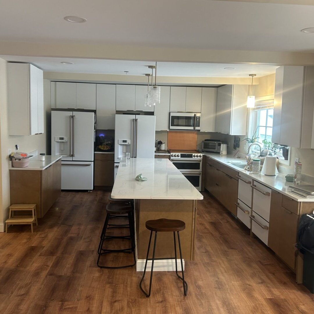 Bright modern kitchen with island and wooden stools.